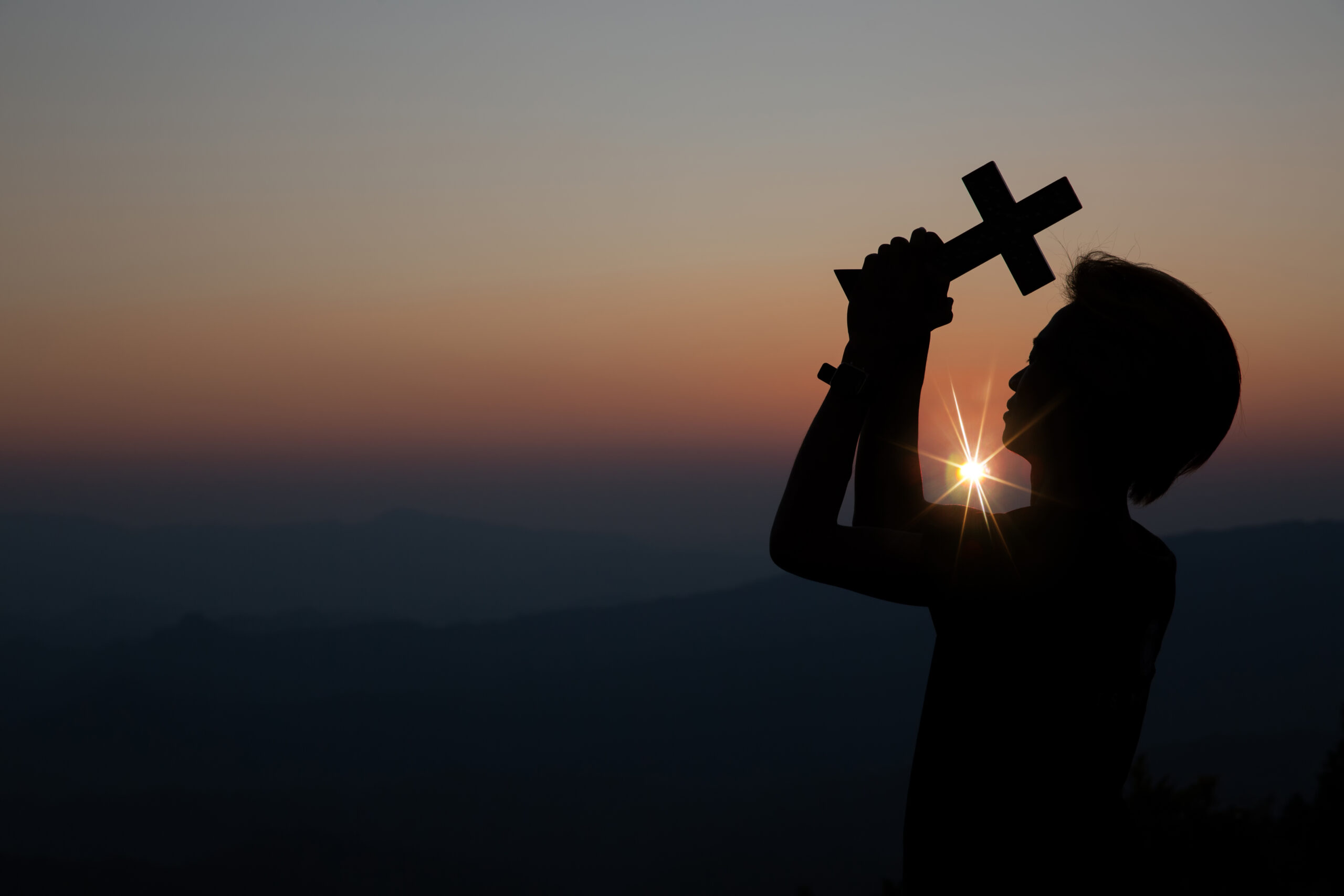 Faith of christian concept: Spiritual prayer hands over sun shine with blurred beautiful sunset background